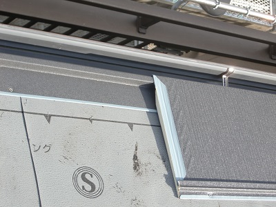 防水シートの上から金属の屋根材を被せていく様子