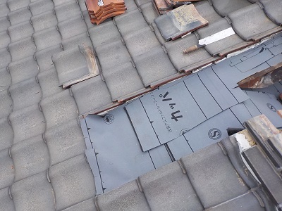 解体した屋根の上に防水シートを敷いた様子