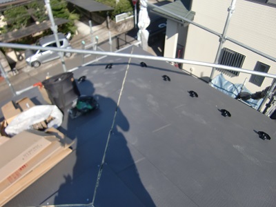 金属の屋根材を被せていく様子