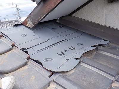 解体した屋根の上に防水シートを敷いた様子