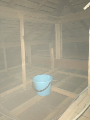 雨漏りを受ける天井裏のバケツ
