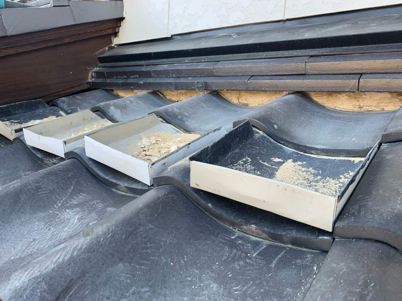 既設漆喰の撤去中は外に落ちないように塵取りが必須