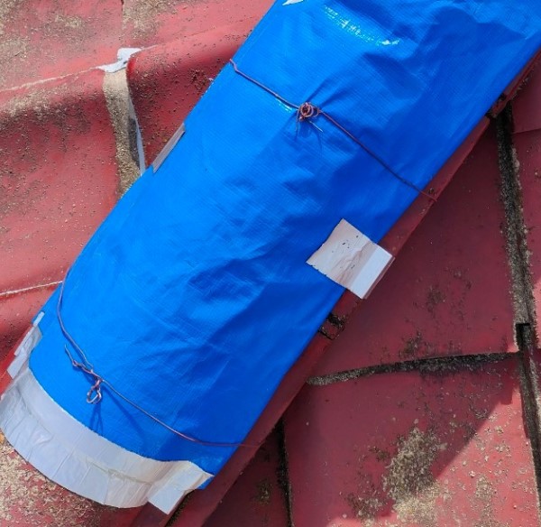 ブルーシートで雨漏りの応急処置を行い、結束銅線とブチルテープで固定