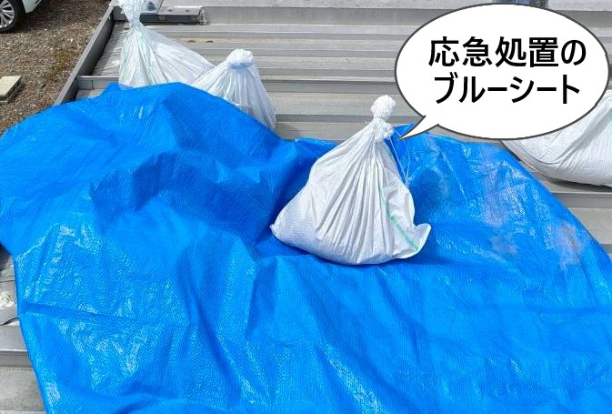 ユニットハウスの屋根にかけられた応急処置のブルーシート