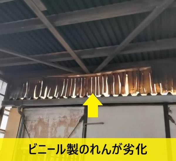 倉庫の壁にあるビニール製のれんが劣化している