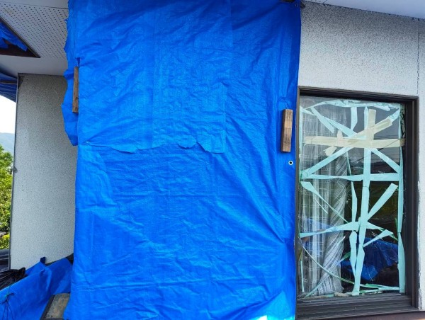 地震で剥がれた外壁にブルーシート養生
