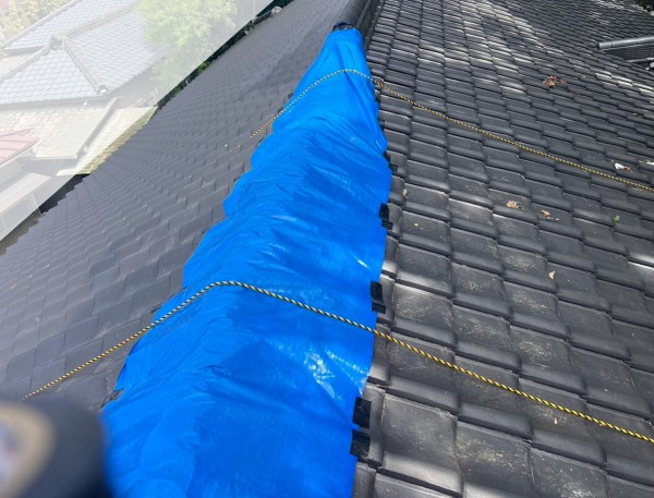 地震で崩落した瓦屋根の棟にブルーシート養生