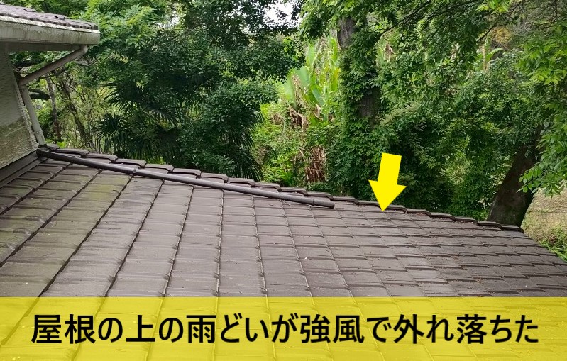 屋根の上の雨どいが強風で外れ落ちている