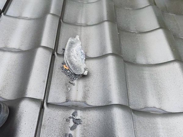 棟から欠けた漆喰が屋根に落ちている