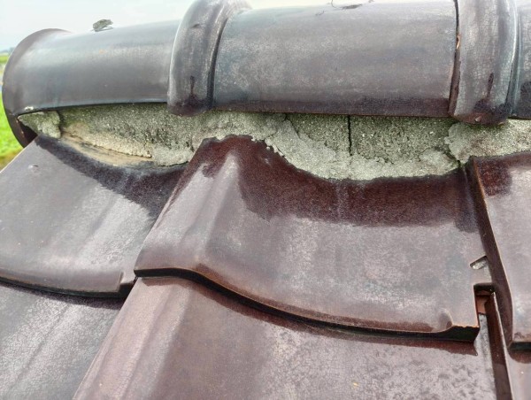 棟瓦がずれて漆喰も割れている