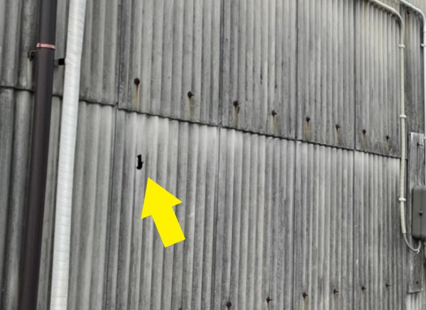 波スレートの外壁に穴が開いている