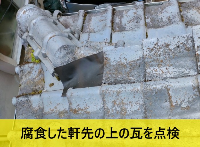 腐食した軒天の上の瓦を点検