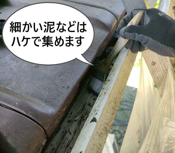 軒樋に溜まった泥などはハケで集めて清掃しています