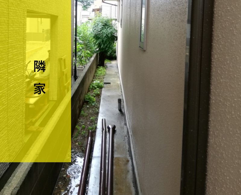 雨樋が外れて隣家に水はねしている住宅