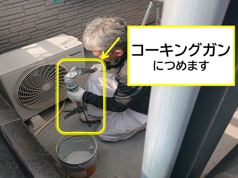 紀の川市の外壁塗装で主剤と硬化剤を撹拌したコーキング材をコーキングガンに詰める作業の写真