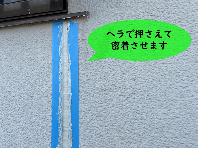 紀の川市の誘発目地にコーキングを充填しヘラで密着させます