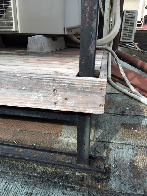  屋根上に設置された架台と木製部分の劣化状態。接合部からの雨水浸入リスクが懸念される状況