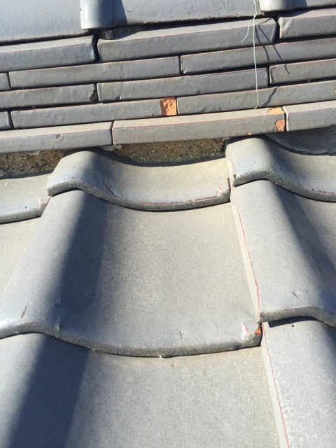 八尾市青山町の屋根調査、棟下の漆喰が剥がれ落ちて内部の茶色い土が露出した危険な状態