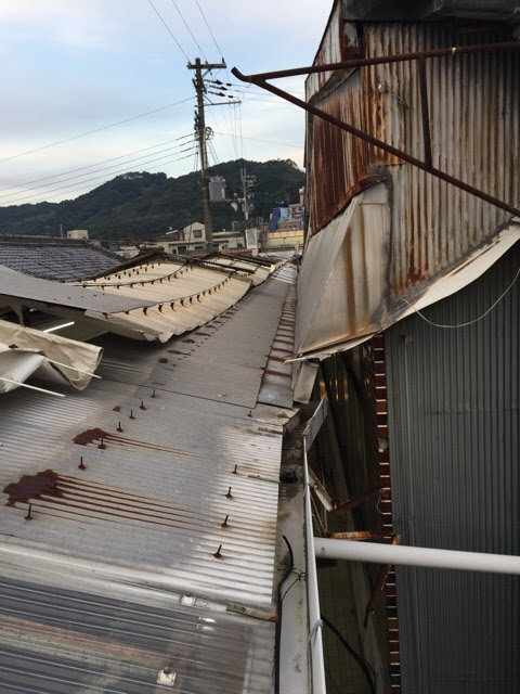 金具から出たサビが下部の波板屋根に流れ落ちて固着している様子