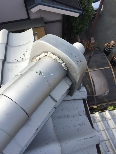 東大阪市での屋根調査。鬼瓦周りの白い漆喰（しっくい）が劣化して剥がれている状態。