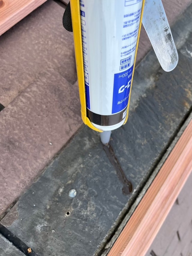 コーキングガンを使用して屋根の隙間を防水補修する工程