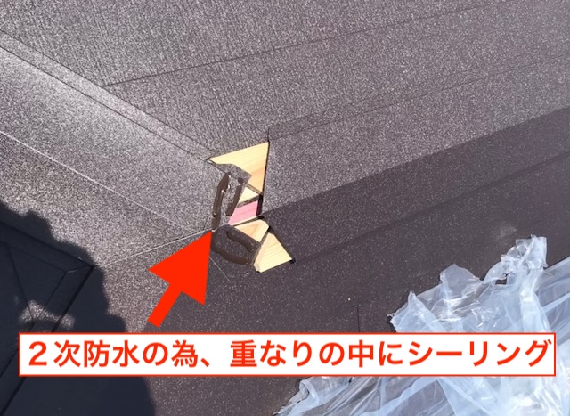 屋根の形状に合わせて金属屋根材を精密にカットし、接合部を処理している職人技