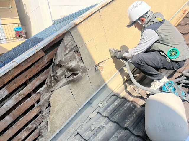 グラインダーを使用して傷んだ外壁部分を慎重にカット・撤去する作業