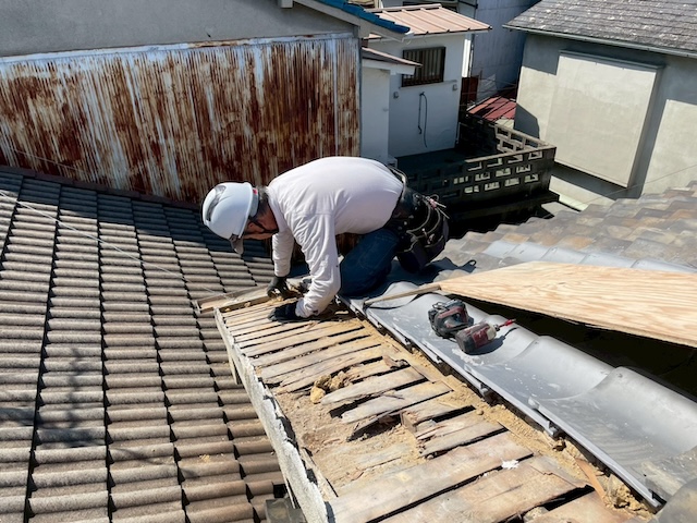 露出したバラ板を補修し新しい下地木材の高さをミリ単位で調整する職人の作業風景