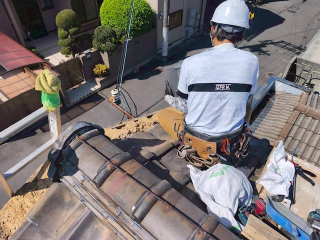 防水シートを敷き込み細部の雨仕舞いが完璧になされているか確認する職人の様子