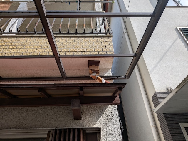 テラス屋根上部でガムテープ補修が劣化し破断している這い樋