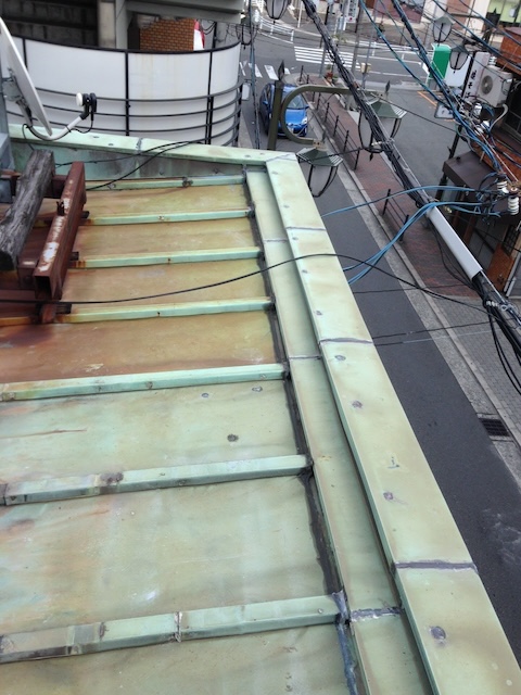 大阪市西成区の雨漏り調査、経年劣化で変色した銅板屋根と箱樋（屋根の端にある水路）