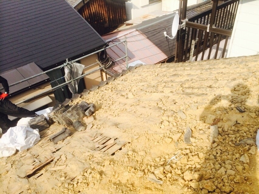 古い日本瓦と劣化した大量の屋根土を撤去している作業風景