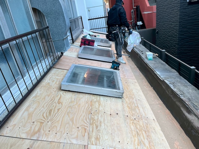 天窓周辺の採寸を行いながら、隙間なく構造用合板を設置していく職人の様子。