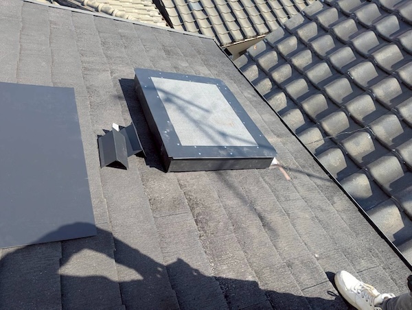 既存の屋根に合わせて現場で加工したガルバリウム鋼板（板金）を設置している様子