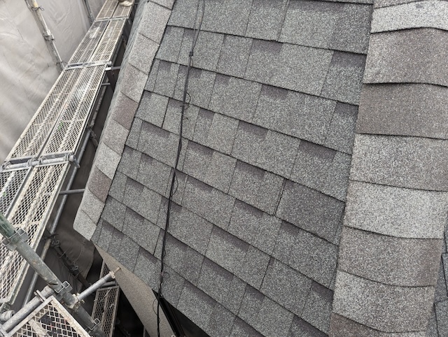 高い耐久性と洗練されたデザイン性を誇る、美しく完工したグレーのアスファルトシングル屋根の接写