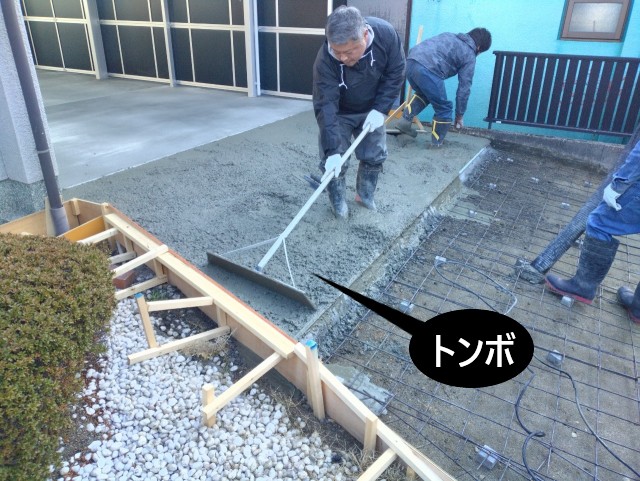 トンボでコンクリート面を押さえつけるように均す