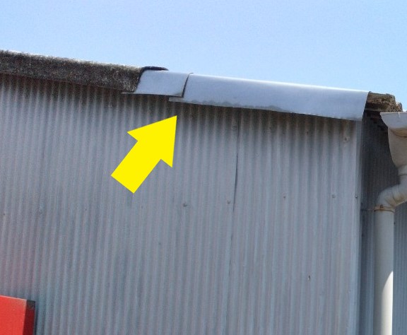 波型スレートが破損して補修を行った跡