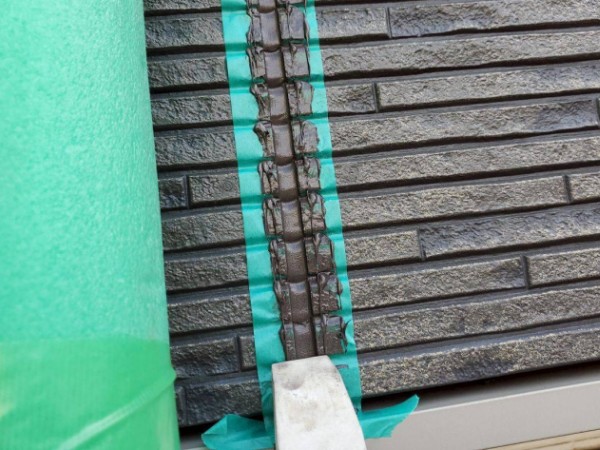 目地シーリングをヘラでならしている