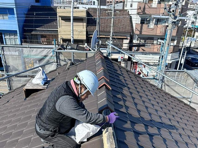 棟瓦取り直し工事で既存棟瓦の取り外しを行う屋根職人