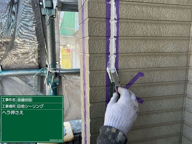 コーキング材をへらでならす様子