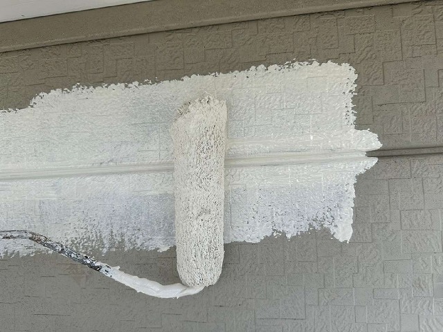 劣化で色あせた金属サイディングに3回塗り工程の下塗りの様子