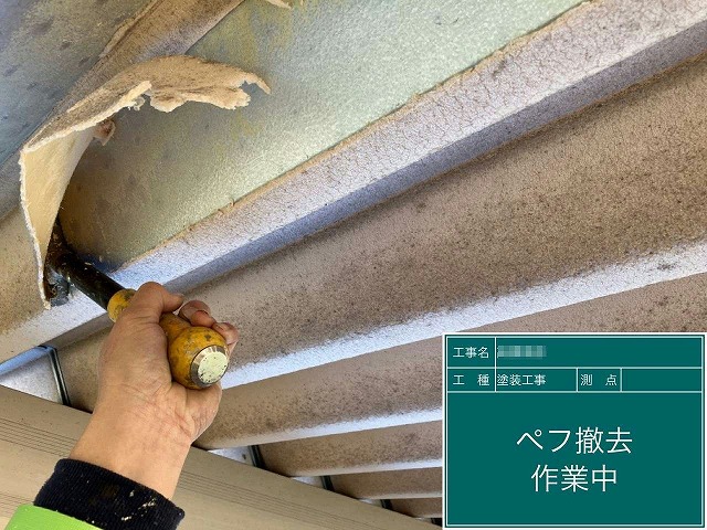 スクレーパーを使って折板屋根のペフを除去している様子