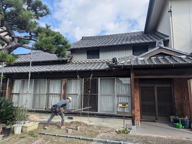 屋根の葺き替えによる軽量化リフォームを行うための足場の組み立てを行う足場職人