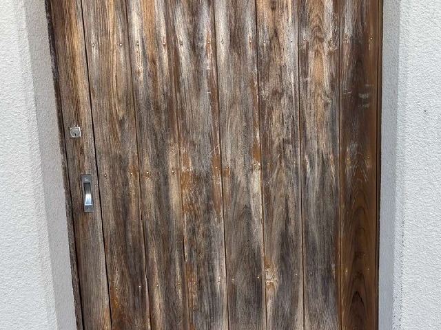 和風住宅の木製ドアが劣化して変色やシミ、カビが目立っている状況