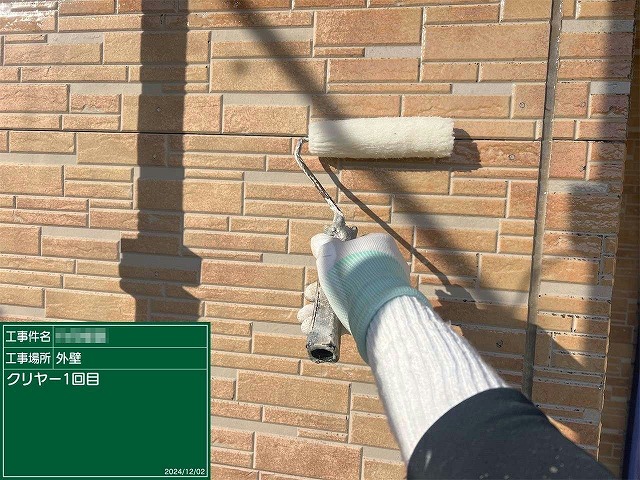 石目調サイディング外壁に対するクリヤー塗装1回目の様子