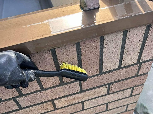 天白区　外壁タイル目地込み工事のブラシで表面を清掃している様子