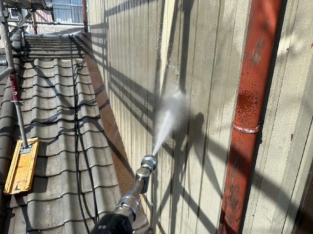 劣化で色あせたトタン外壁への高圧洗浄作業
