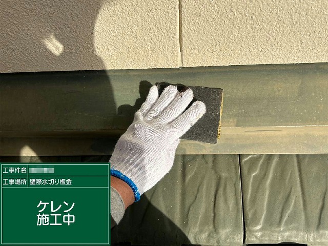 雨押え板金にサンドペーパーでケレンを行っている施工の様子