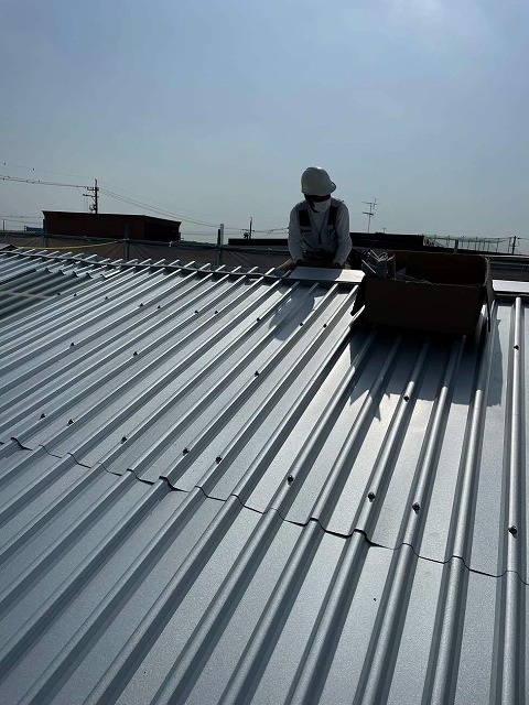 ガルバリウム鋼板屋根を用いたカバー工法で棟板金を設置する屋根職人
