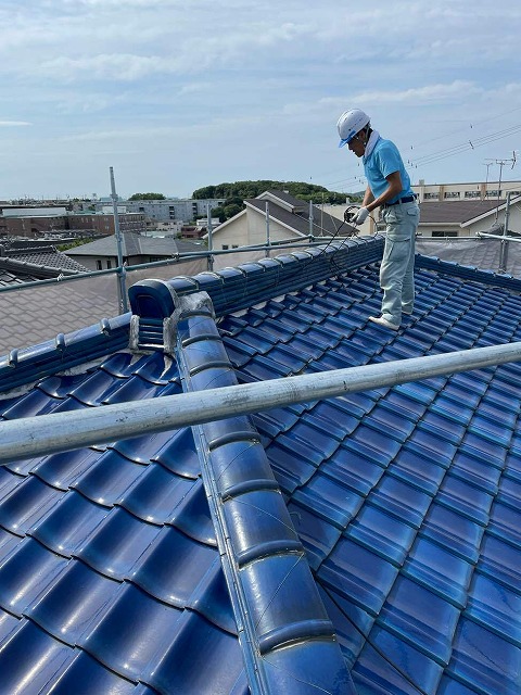 屋根葺き替え工事でアンテナ線を撤去する屋根職人